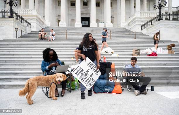 Rep. Cori Bush, D-Mo., holds a "housing is a human right" sign at the House steps on Saturday morning, July 31, 2021. Rep. Bush, along with Reps....