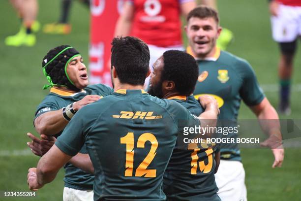 South Africa's center Lukhanyo Am is celebrated by teammates for scoring a try during the second rugby union Test match between South Africa and the...