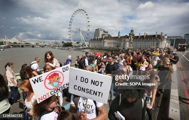 Protesters hold placards during the demonstration. Children and their parents protest in Central London against continued Covid-19 restrictions and...