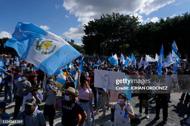 Demonstrators hold Guatemalan flags during a protest to demand the resignation of Guatemala's President Alejandro Giammattei and Attorney General...