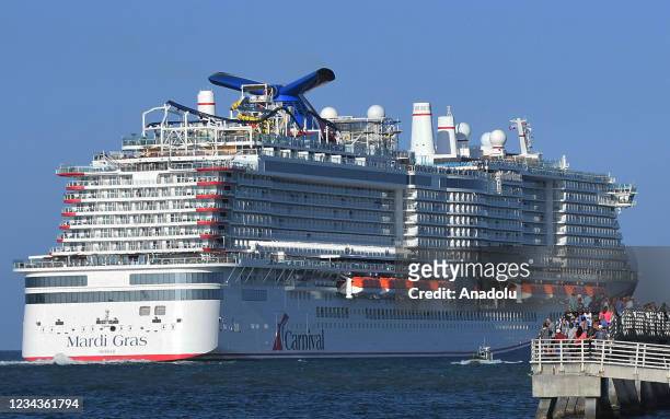 People gather on the fishing pier to watch the new Carnival Cruise Line ship Mardi Gras as it departs on its maiden voyage, a seven-day cruise to the...