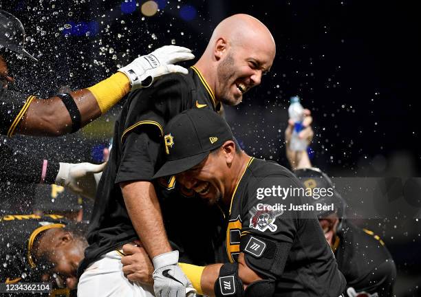 Jacob Stallings of the Pittsburgh Pirates is hugged by Phillip Evans after hitting a walk-off RBI fielders choice single to give the Pirates a 3-2...