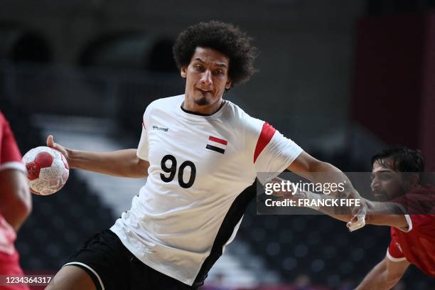 Egypt's left back Ali Mohamed is challenged during the men's preliminary round group B handball match between Egypt and Bahrain of the Tokyo 2020...