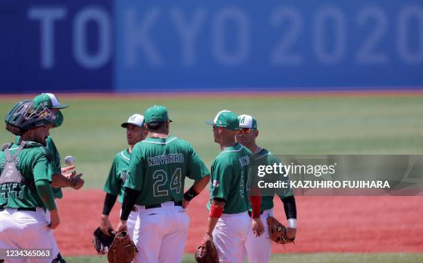 Mexico's team manager Benjamin Gil speaks to infield players at the pitcher's mound to substitute pitcher to Sasagi Sanchez during the third inning...