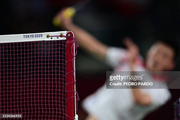 "Tokyo 2020" is pictured on the net as China's Chen Long hits a shot to Indonesia's Anthony Sinisuka Ginting in their men's singles badminton...