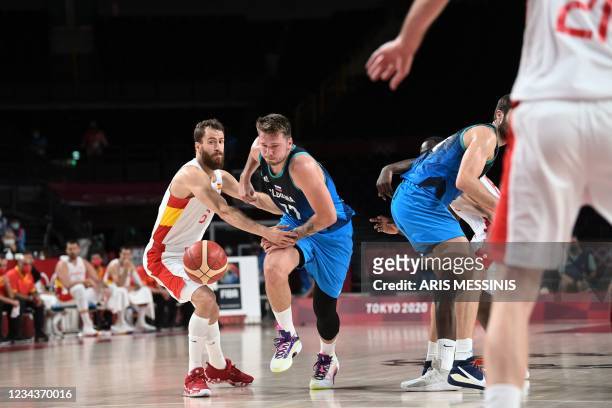 Slovenia's Luka Doncic dribbles the ball past Spain's Sergio Rodriguez in the men's preliminary round group C basketball match between Spain and...
