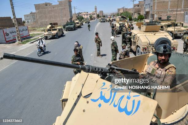 An Afghan National Army commando stands guard on top of a vehicle along the road in Enjil district of Herat province on August 1 as skirmishes...