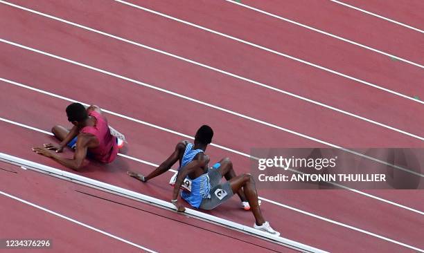 S Isaiah Jewett and Botswana's Nijel Amos react after falling on the track while competing in the men's 800m semi-finals during the Tokyo 2020...