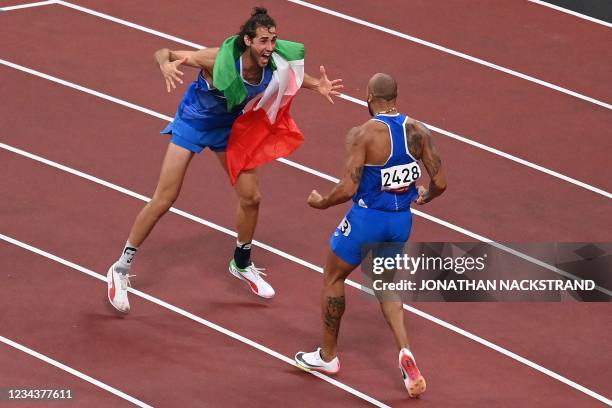 Italy's Lamont Marcell Jacobs celebrates with high jumper Italy's Gianmarco Tamberi after winning the men's 100m final during the Tokyo 2020 Olympic...