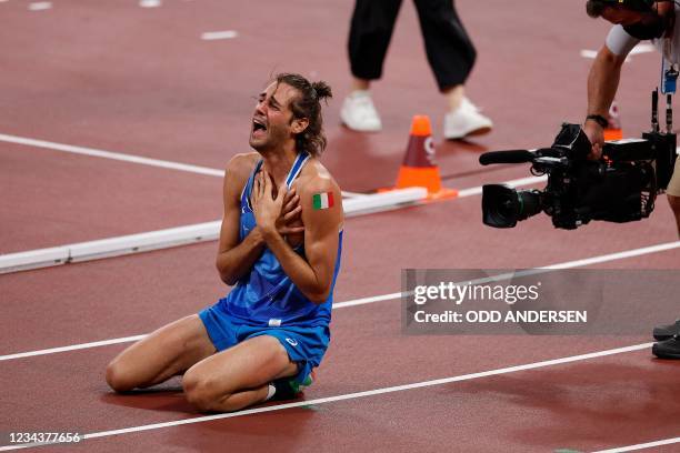 First-placed Italy's Gianmarco Tamberi celebrates after competing in the men's high jump final during the Tokyo 2020 Olympic Games at the Olympic...