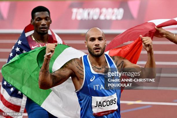Italy's Lamont Marcell Jacobs celebrates his victory next to silver medallist USA's Fred Kerley after the men's 100m final during the Tokyo 2020...