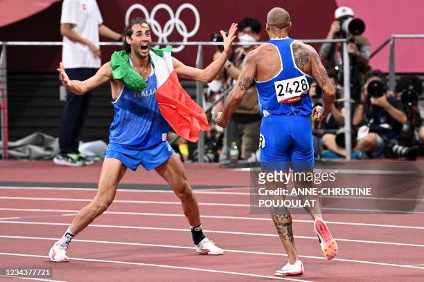 Italy's Lamont Marcell Jacobs celebrates with high jumper Italy's Gianmarco Tamberi after winning the men's 100m final during the Tokyo 2020 Olympic...
