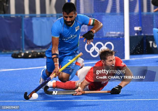 Britain's Liam Paul Ansell falls as he vies for the ball with India's Manpreet Singh during their men's quarter-final match of the Tokyo 2020 Olympic...