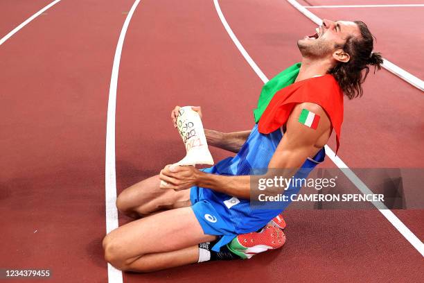 Gold medalist Italy's Gianmarco Tamberi celebrates on the track following the Men's High Jump Final during the Tokyo 2020 Olympic Games at the...
