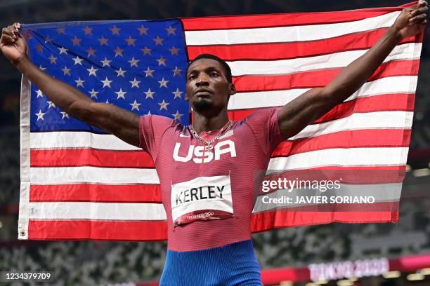 S Fred Kerley celebrates with the flag of the USA after placing second of the men's 100m final during the Tokyo 2020 Olympic Games at the Olympic...