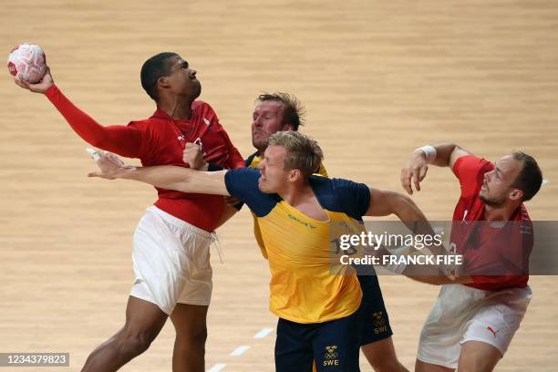 Denmark's centre back Mads Mensah Larsen vies with Sweden's pivot Fredric Pettersson during the men's preliminary round group B handball match...