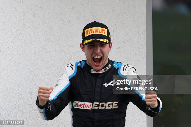 Winner Alpine's French driver Esteban Ocon celebrates as he arrives on the podium after the Formula One Hungarian Grand Prix at the Hungaroring race...