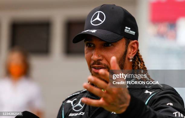 Mercedes' British driver Lewis Hamilton gives an interview after the Formula One Hungarian Grand Prix at the Hungaroring race track in Mogyorod near...