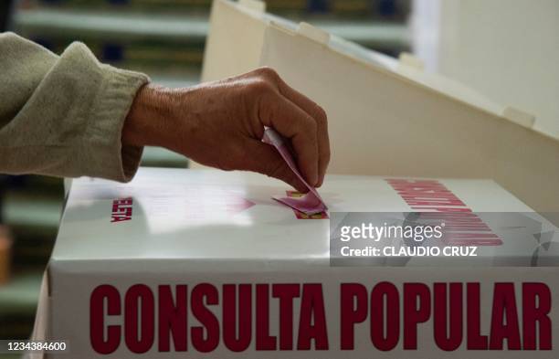 Woman casts her vote during a national referendum in Mexico City, on August 1, 2021. - Mexicans voted Sunday in a national referendum promoted by...