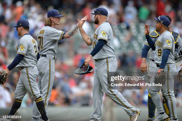 Luis Urías, Josh Hader, #71, Rowdy Tellez, and Eduardo Escobar of the Milwaukee Brewers celebrate after winning against the Atlanta Braves at Truist...