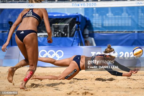 S Alix Klineman watches as partner April Ross dives for the ball in their women's beach volleyball round of 16 match between Cuba and the USA during...