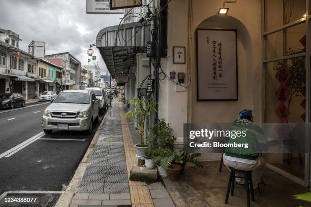 Grab Food rider waits to pick up order in a deserted street in Phuket Old Town, Thailand, on Sunday, Aug. 1, 2021. Although the Phuket sandbox model...