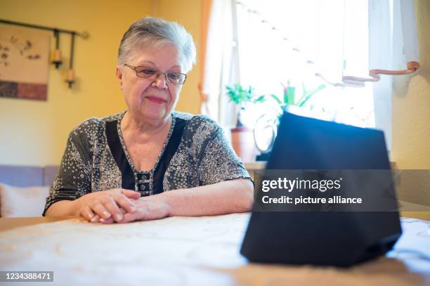 July 2021, Rhineland-Palatinate, Zweibrücken: Ursula Reinhard sits at the kitchen table and calls a friend with her Alexa. As part of the project...