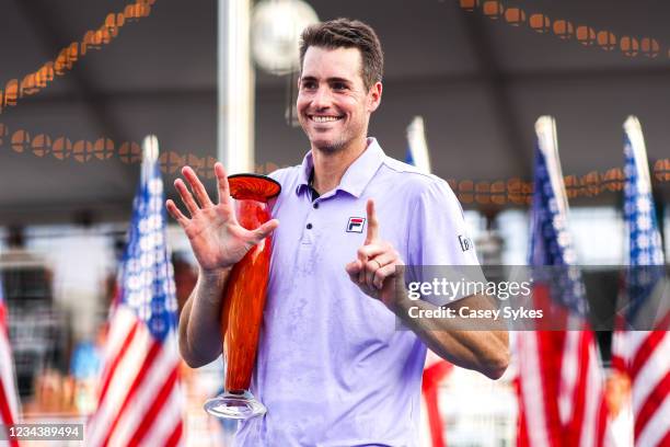 John Isner of the United States holds up six fingers, signifiying his six Atlanta Open victories, while holding the winners trophy after winning the...