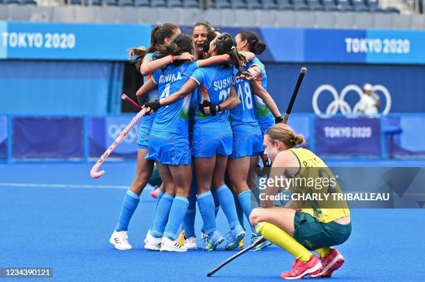 Players of India celebrate after defeating Australia 1-0 as Australia's Renee Taylor squats at the end of their women's quarter-final match of the...