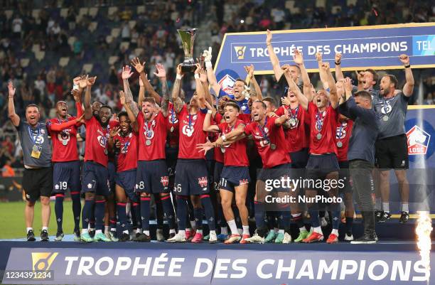 Lille's players celebrate with the trophy after winning the French Champions' Trophy final football match between Paris Saint-Germain and Lille at...