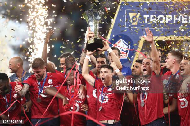 Lille's players celebrate with the trophy after winning the French Champions' Trophy final football match between Paris Saint-Germain and Lille at...