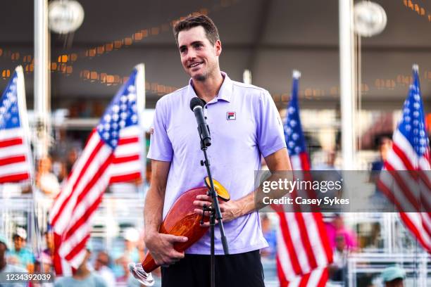 John Isner of the United States speaks while holding the winners trophy after winning the singles final match against Brandon Nakashima of the United...