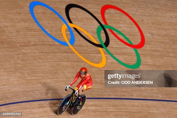 China's Zhong Tianshi rides past the Olympic Rings after setting a new World Record during first round heats for the women's track cycling team...