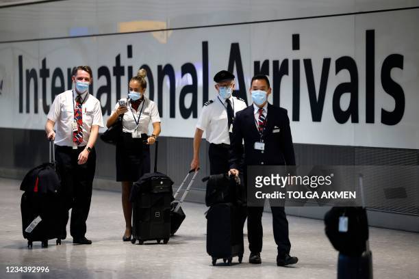 Cabin crew arrive at Heathrow's Terminal 5 in west London on August 2, 2021 as quarantine restrictions ease. - People fully vaccinated in the United...