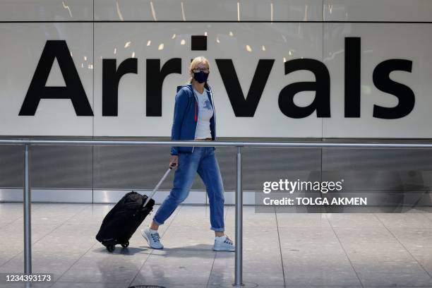 Travellers arrive at Heathrow's Terminal 5 in west London on August 2, 2021 as quarantine restrictions ease. - People fully vaccinated in the United...
