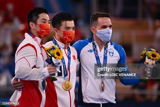 China's Hao You , China's Yang Liu and Greece's Eleftherios Petrounias pose during the medal ceremony of the artistic gymnastics men's rings of the...