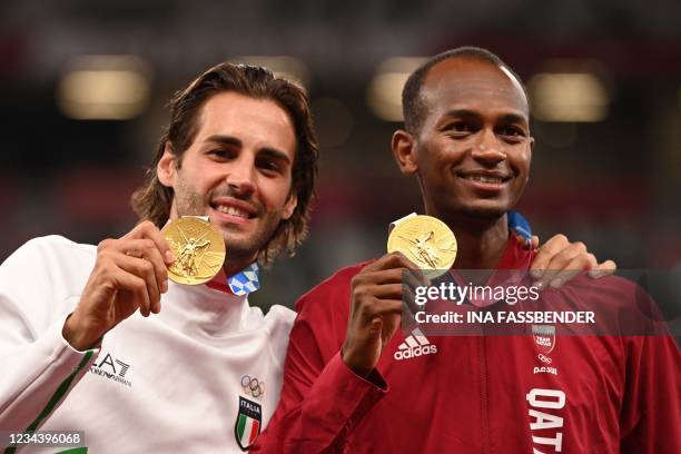 Joint gold medalists Qatar's Mutaz Essa Barshim and Italy's Gianmarco Tamberi pose on the podiumn of the men's high jump final during the Tokyo 2020...