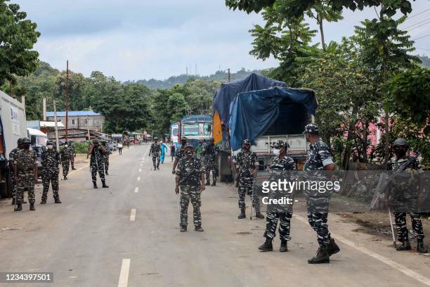 This picture taken on August 1, 2021 shows Central Reserve Police Force personnel standing guard at the national highway in Lailapur area near...