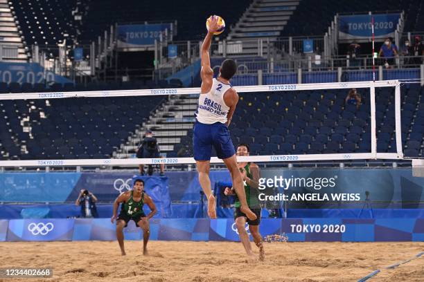 Brazil's Alvaro Morais Filho spikes the ball in their men's beach volleyball round of 16 match between Mexico and Brazil during the Tokyo 2020...