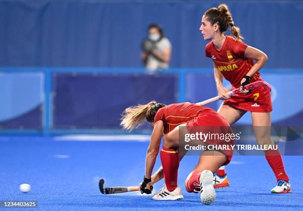 Spain's Maria Lopez strikes the ball next to teammate Carlota Petchame before the team scored against Britain during their women's quarter-final...