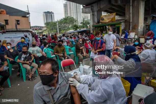 Health worker injects a dose of Sinovac COVID-19 vaccine made by Biofarma during a COVID-19 vaccination drive at traditional market in Jakarta on 2...