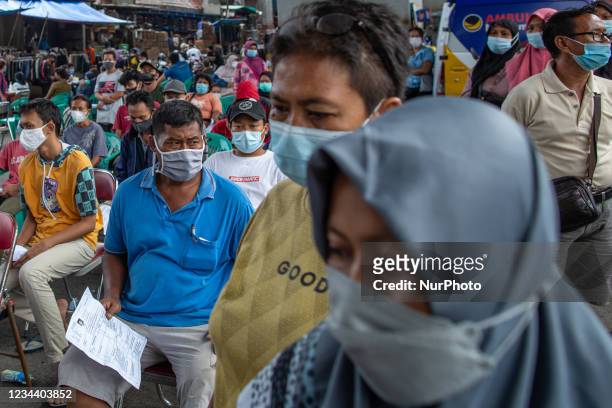 People wait to register for the Sinovac COVID-19 vaccine made by Biofarma during a COVID-19 vaccination drive in Jakarta on 2 August 2021. According...