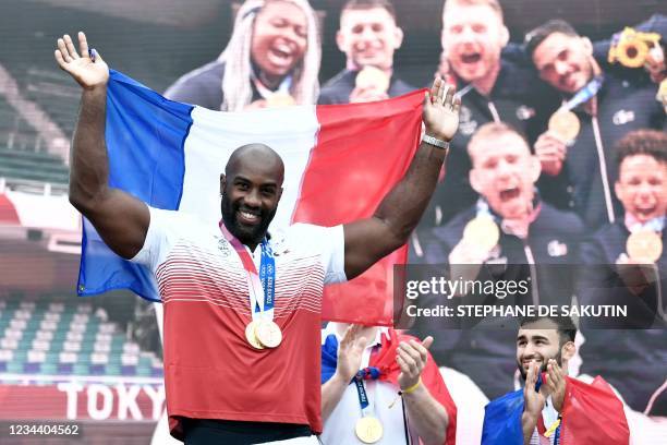 French Judoka, heavyweight bronze medallist and mixed team gold medallist, Teddy Riner celebrate on stage with fellow medal winners Judoka upon their...