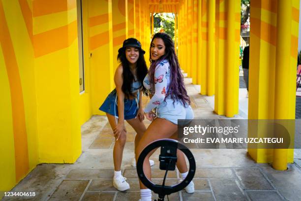 Women dance in front of a phone to record a Tiktok video, in Miami, Florida on January 09, 2021.