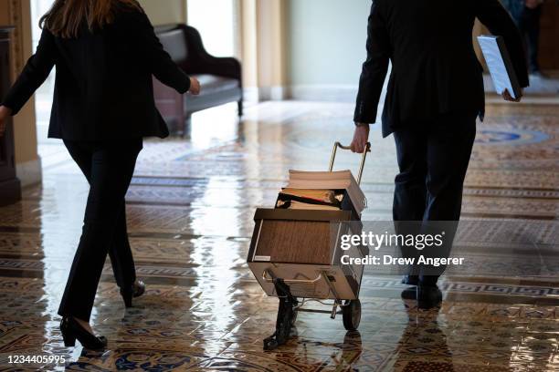 Documents, including text of the bipartisan infrastructure legislation, is wheeled toward the office of Senate Majority Leader Chuck Schumer at the...