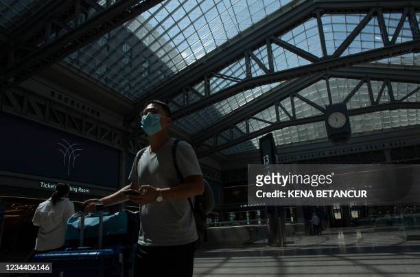Man wears a face mask as he arrives to Penn station in New York on August 2, 2021. - New York Mayor Bill de Blasio stopped short of ordering a mask...