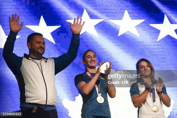 Kosovo's judo coach Driton Kuka , flanked by Kosovo's Gold medallists judokas Nora Gjakova and Distria Krasniqi waves during a welcoming ceremony in...