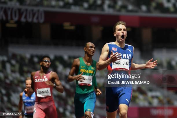 Norway's Karsten Warholm reacts as he wins and breaks the world record in the men's 400m hurdles final during the Tokyo 2020 Olympic Games at the...