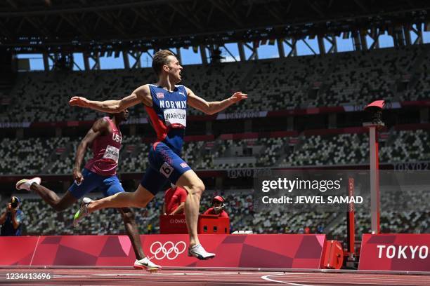 Norway's Karsten Warholm crosses the finish line to win break the world record in the men's 400m hurdles final during the Tokyo 2020 Olympic Games at...