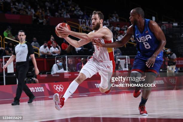 Spain's Sergio Rodriguez runs with the ball past USA's Khris Middleton in the men's quarter-final basketball match between Spain and USA during the...